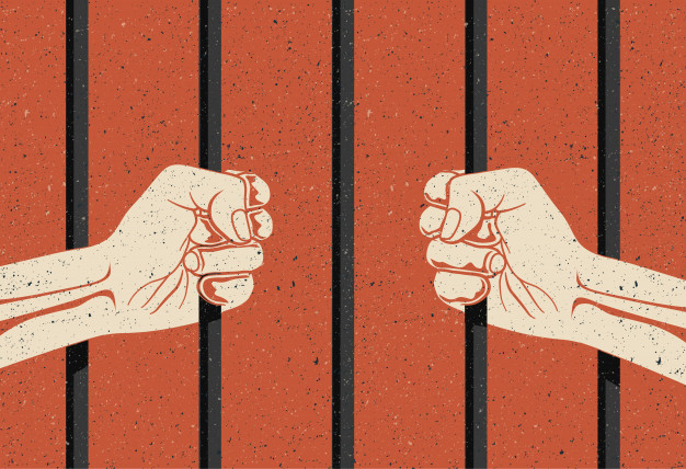 Punitivismo: unas manos sosteniendo las barras de una celda de prisión
